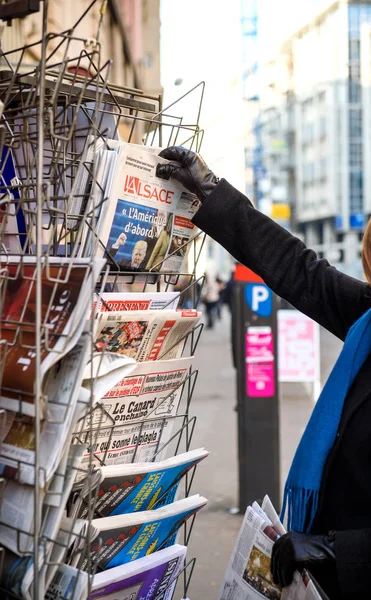 Mujer compra el periódico francés L 'Alsace en un quiosco — Foto de Stock