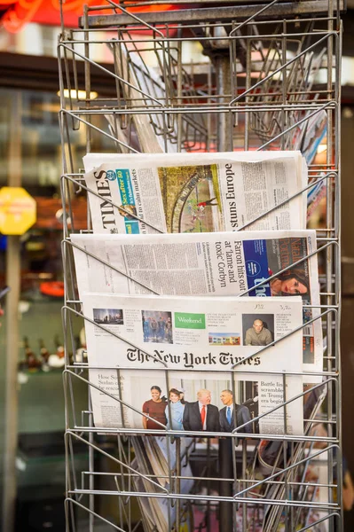 New York Times, a The Guardian napilap-ból egy újságos — Stock Fotó