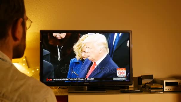 Человек, смотрящий церемонию инаугурации Дональда Трампа — стоковое видео