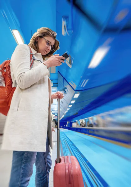 Elegant kvinna med i metro tåg stationen järnväg tube smartpho — Stockfoto