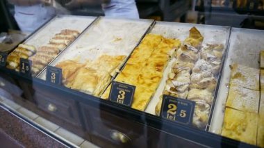 BUCHAREST, ROMANIA - CIRCA 2017: Bükreş 'teki tipik sokak yemeklerine bakan müşterilerin bakış açısı Romanya fırınında sıcak ve lezzetli yiyecekleri bekleyen müşterilerle birlikte diğer hamur işlerini satmaları