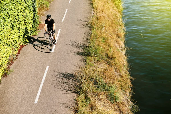 Взрослый мужчина катается на велосипеде по воздуху возле реки Франция — стоковое фото