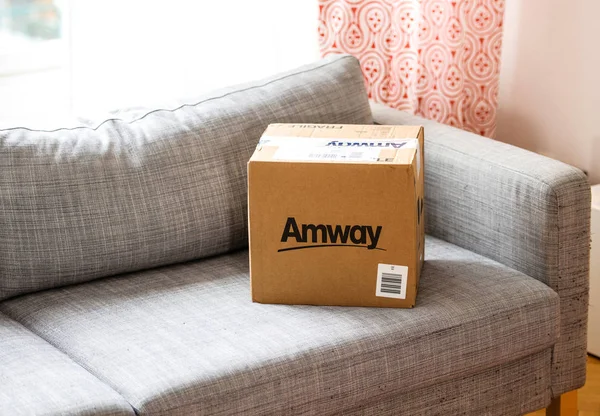 Caja de cartón Amway en sofá para desempacar —  Fotos de Stock