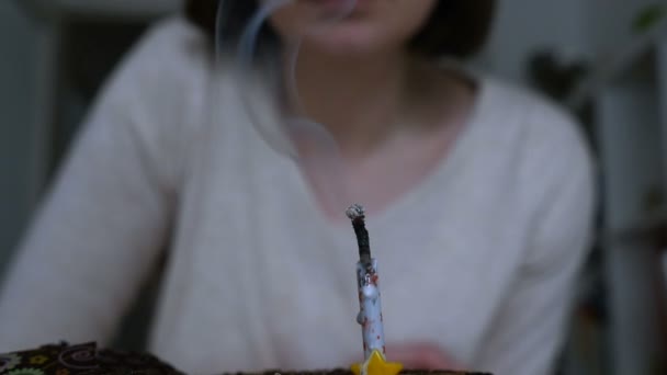 Женщина задувает свечу на день рождения — стоковое видео