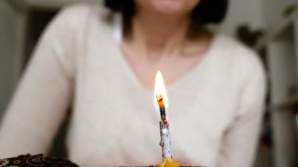 Жінка дме свічку на день народження — стокове відео