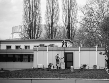 İşçiler bir binanın çatı onarımı