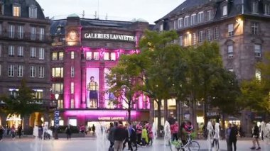 STRASBOURG, FRANCE - CIRCA 2017: Alacakaranlıkta General Kleber 'in Yeri' ndeki Lafayette Majestic Galerileri binası ve Strasbourg 'un merkezinde akşam karanlığında güzel mimari aydınlatmalar