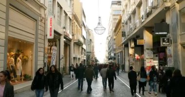 Atina, Yunanistan - 2016 civarı: Gün batımında yayalarla Ermou caddesi bulvarı. Ermou Caddesi, Yunanistan 'ın başkenti Atina' da Kerameikos arkeolojik alanını birbirine bağlayan bir buçuk kilometre uzunluğunda bir yol.