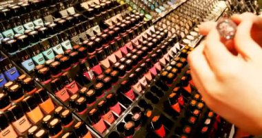 PARIS, FRANCE - CIRCA 2016: Sephora 'da mümkün olan tüm renklerde tırnak cilası seçimi yapan müşteri kadınların bakış açısı. Sephora, 1969 yılında kurulan Fransız kozmetik mağaza zinciri.