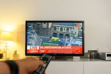 Uzaktan kumanda Bbc kanalı raporlama izlerken tutan adam