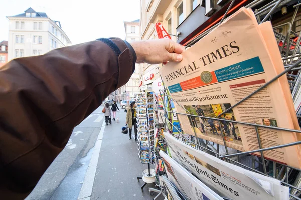 Man purchases a Financial times newspaper from press kiosk after — Stock Photo, Image