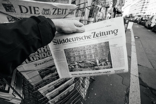 Man purchases Sddeutsche zeitung  newspaper from press kiosk