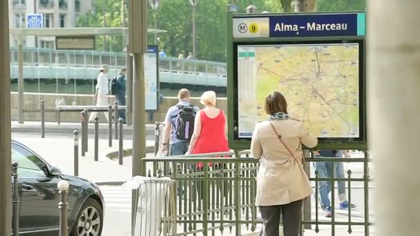 フランス Circa 2016 パリで最高のナビゲーションルートを得るために公共地図を読む女性 暖かい晴れた日にアルマ マルソー地下鉄駅 — ストック動画
