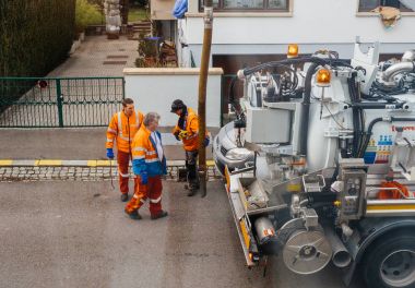workers using sewerage truck and large pipe working on the clogg clipart