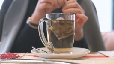 Genç kadın çay infüzyon, cam fincan organik çay hazırlama