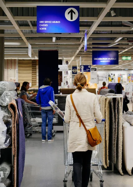 Mulher comprando tapetes na loja de móveis Ikea — Fotografia de Stock