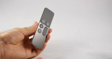 Paris, Fransa - 2017 yaklaşık: adam beyaz arka plan karşı yeni Apple Tv cihaz yeni Apple dokunmatik Siri uzaktan kontrolünü denetleme