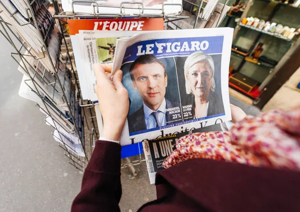 Женщина покупает международную прессу с Эммануэлем Макроном и морпехом — стоковое фото