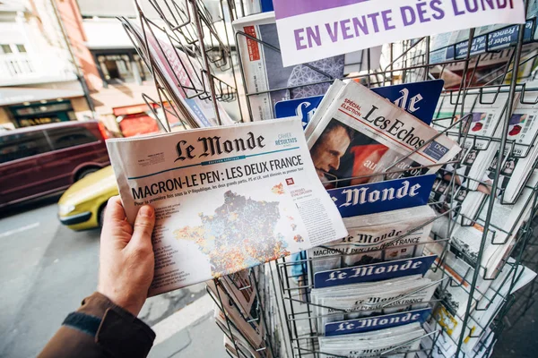 Женщина покупает международную прессу с Эммануэлем Макроном и морпехом — стоковое фото