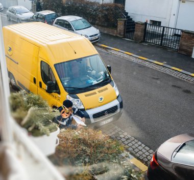 Paris, Fransa - 21 Nisan 2016: Kurye paket parsel görüntülemek yukarıdan zamanında La Poste sarı teslim van ' dır çıkar 