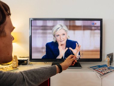Candidate supporter watching debate between Emmanuel Macron and  clipart