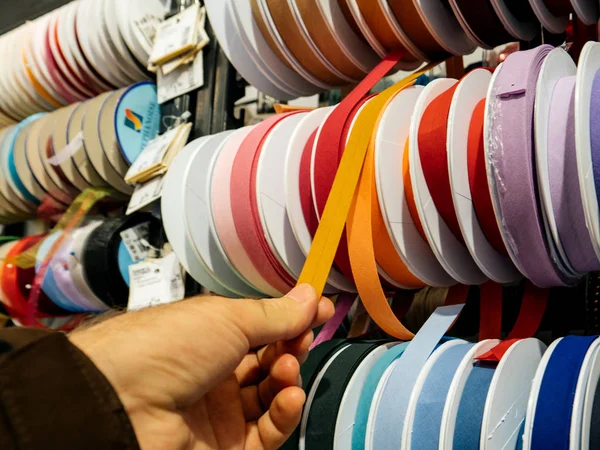 Hombre comprando cintas de colores — Foto de Stock