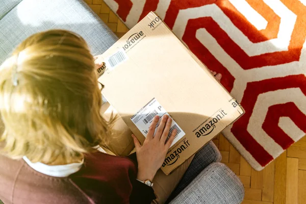 Frau packt amazon.com-Schachtel aus — Stockfoto