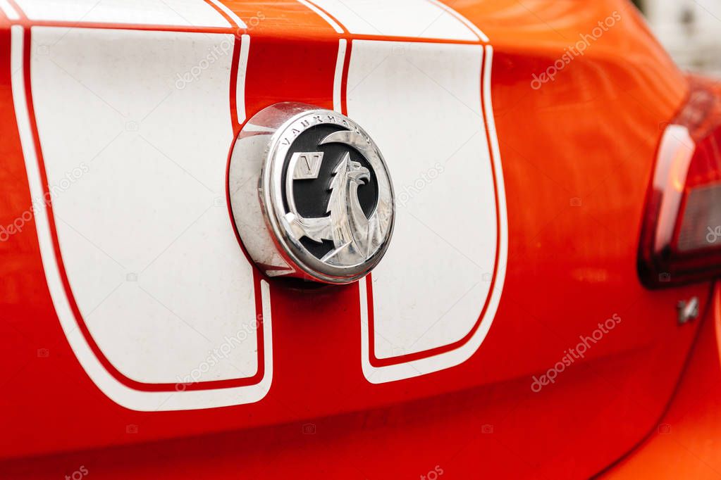 LONDON UNITED KINGDOM - MAR 11, 2017: Vauxhall logotype insignia on a red sport car with white stripes. The Vauxhall logo is based on a mythical creature called the 