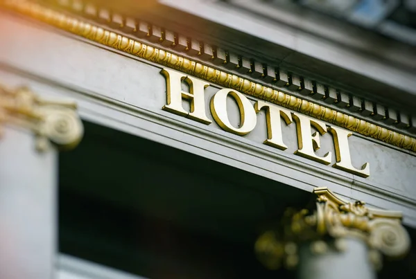 Palabra del hotel con las letras doradas sol destello —  Fotos de Stock