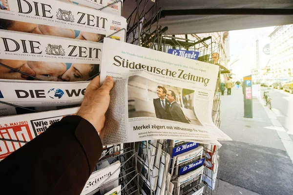 Людину при купівлі Suddeutsche Zeitung з новообраним французький попередньо — стокове фото