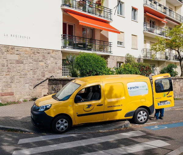 Van amarela la Poste van com trabalhador entregando parcela — Fotografia de Stock