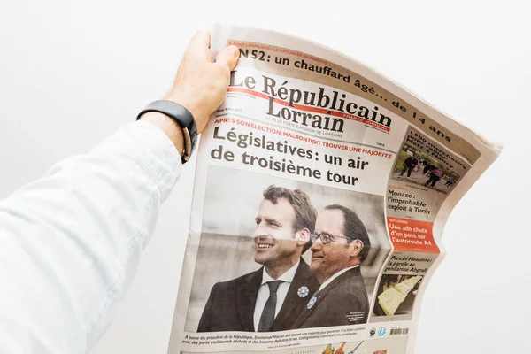 Человек, держащий газету "Ле Републиэн Лоррен" с Эммануэлем Макро — стоковое фото