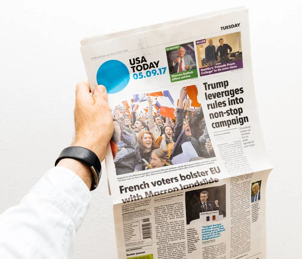 Hombre sosteniendo EE.UU. Hoy periódico con Emmanuel Macron en primer pa — Foto de Stock