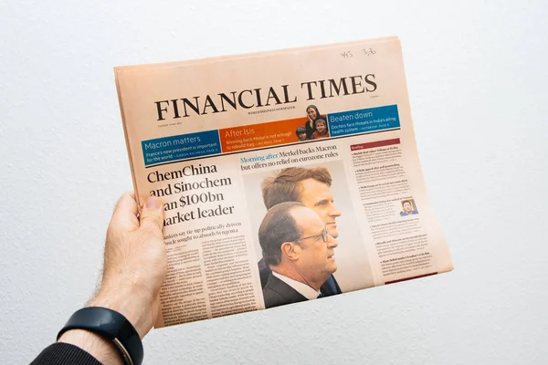 Hombre sosteniendo el periódico Financial Times con Emmanuel Macron en fi — Foto de Stock