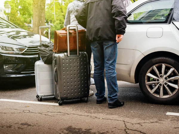 Personas que agregan equipaje múltiple en la ciudad estacionada en el maletero — Foto de Stock