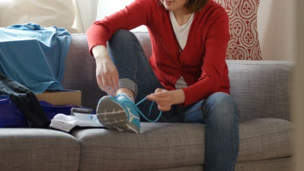 Mujer desempaca zapatos deportivos y ropa — Vídeos de Stock