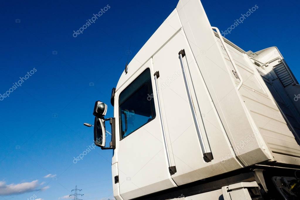 White cargo truck delivering goods cabin against blue sky