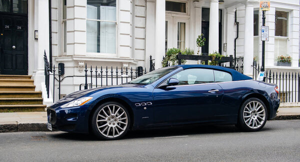 Luxury Maserati blue GranCupe in front of English townhouse 