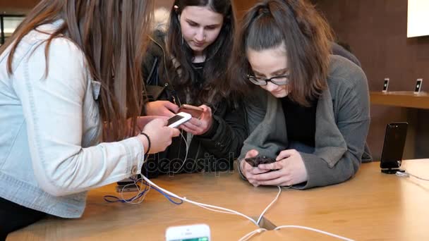 Meninas testando jogar no smartphone iPhone mais recente na Apple Store — Vídeo de Stock