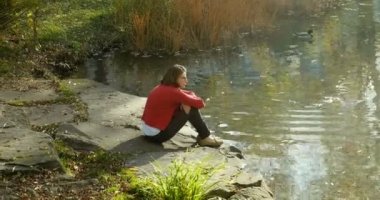 Sonbahar günü sıcak göl ve yeşilbaş ördek hayran dalgın Genç beyaz bir kadın görünümünü arka