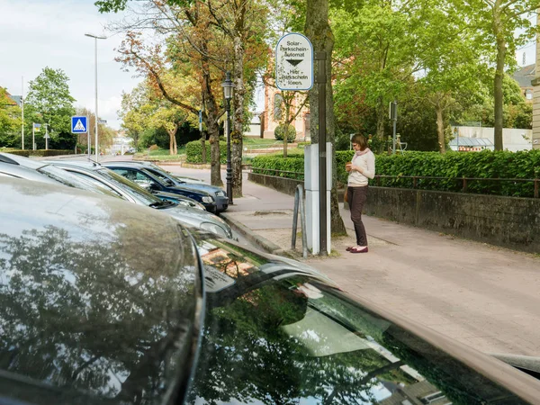 ラシュタットのドイツ都市の都市でテラー駐車場チケット精算機で駐車料金を払い女性のストリート シーン — ストック写真