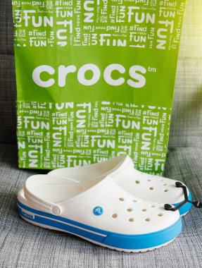 Crocs ayakkabılar alışveriş çantası gri arka plan üzerinde takunya 