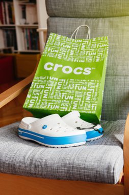 Crocs ayakkabılar alışveriş çantası gri arka plan üzerinde takunya 
