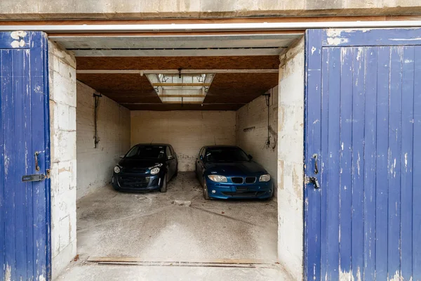Dveře otevřené garáže se dvěma vozy uvnitř — Stock fotografie