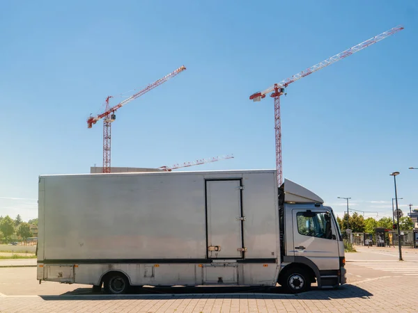 Silver truck parked on the street with construciton cranes worki — Stock Photo, Image