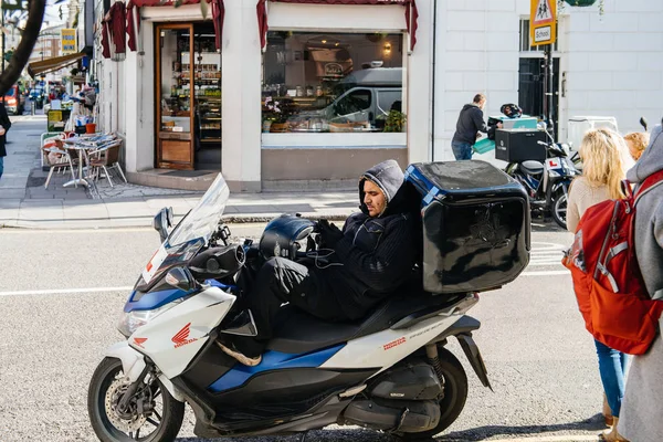 Hombre sentado en motocicleta usando teléfono móvil —  Fotos de Stock