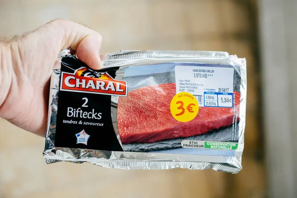 Чоловік тримає Charal biftecks - смачно французький м'яса — стокове фото