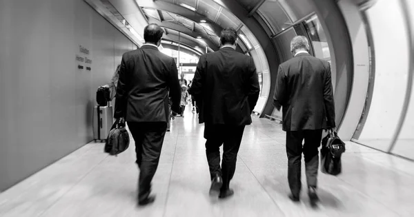 Três homens de negócios caminhando no aeroporto em direção a reunião — Fotografia de Stock