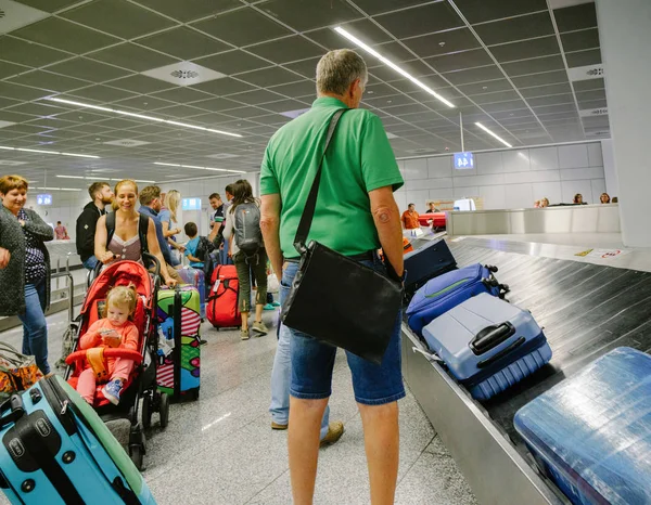Пассажиры, ожидающие получения багажа в моде — стоковое фото