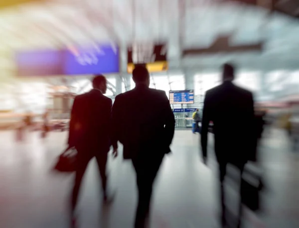 Tres hombres de negocios en la estación de tren caminando hacia la puerta — Foto de Stock